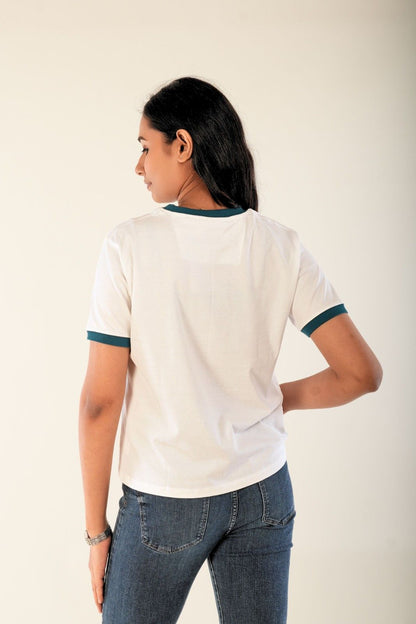 Women’s white tee with teal contrast neck and sleeves, back view, minimal urban streetwear.