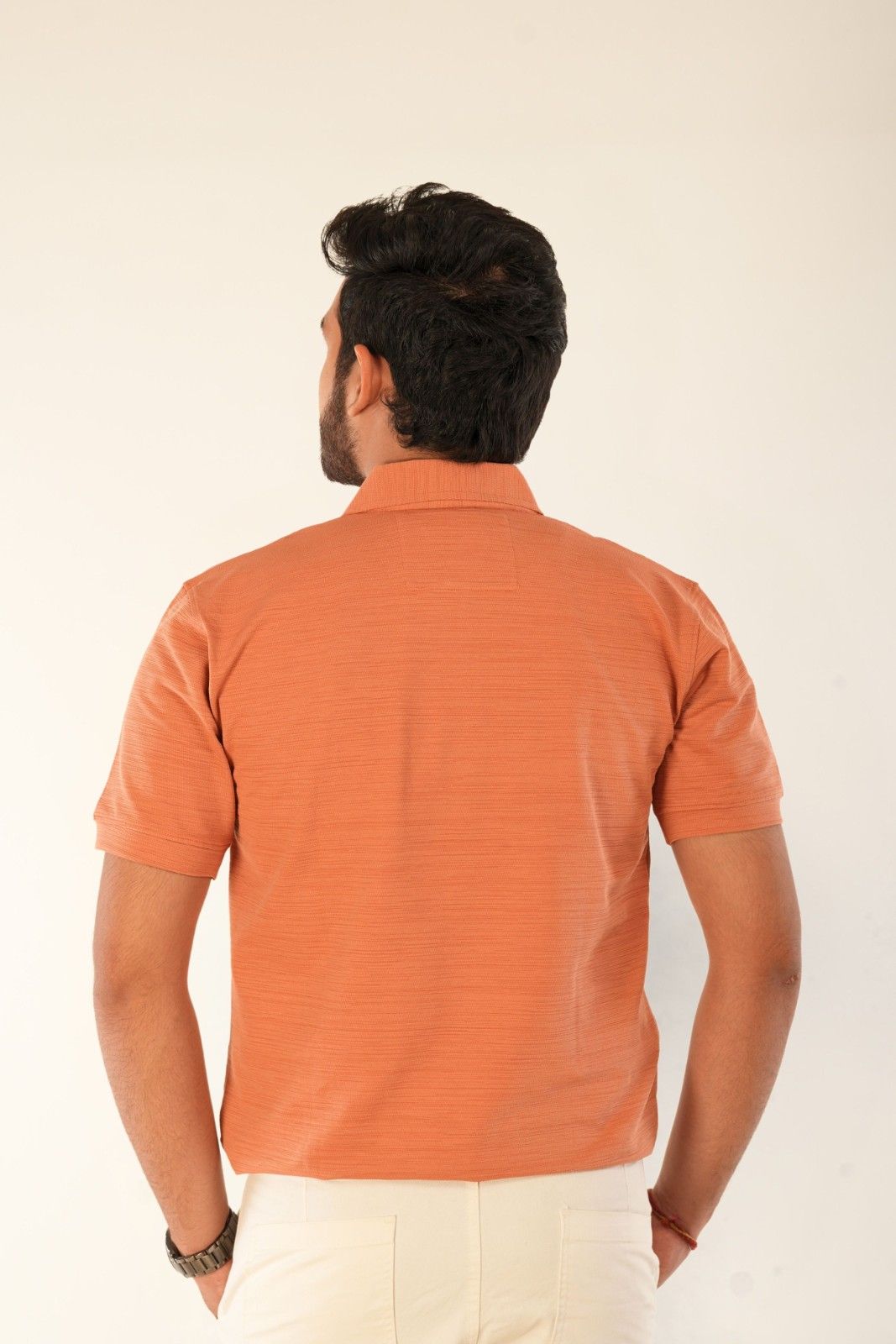 Back view of orange textured piqué polo shirt by Berrys & Cigaredes. Premium cotton construction, structured fit, clean tailoring. Perfect for casual and smart-casual menswear styling.