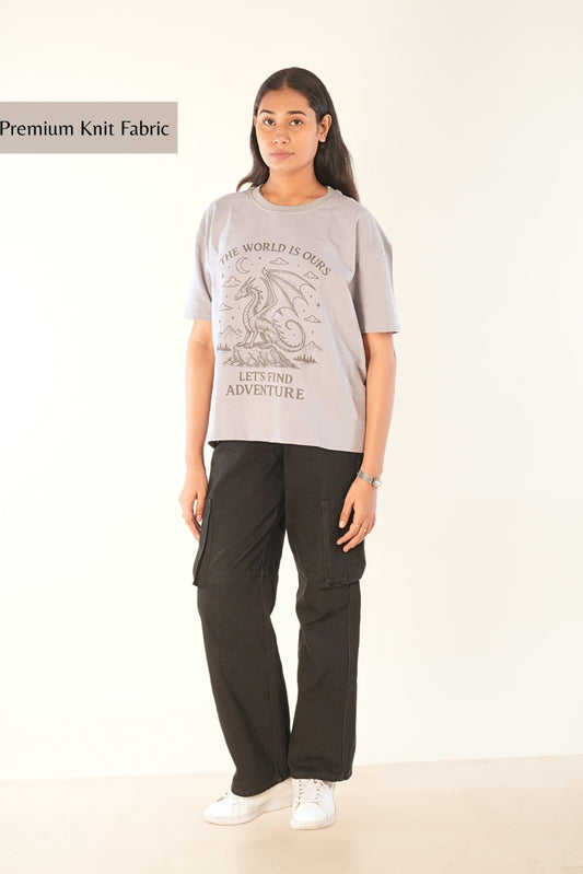 Women's oversized grey graphic t-shirt with fantasy dragon design and adventure text, premium streetwear styling